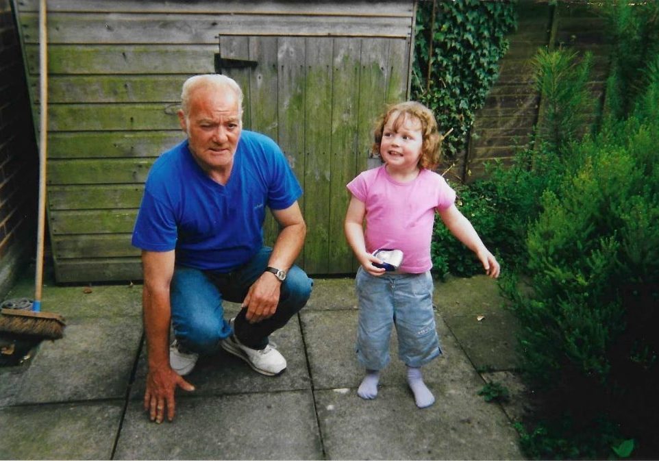 Dad kneeling down next to small girl.