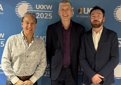 Three men standing next to each other in front of a background with UKKW logos on it.