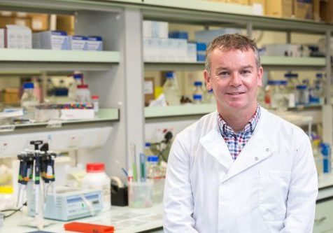 Man in a white lab coat in a research lab